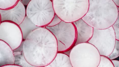 round slices of fresh radish slowly rotate.