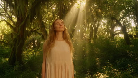 woman standing in a sunlit forest
