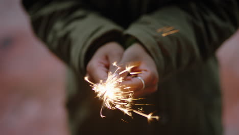 cerrar mujer bengala celebrando la celebración de nochevieja sosteniendo fuegos artificiales festivos en la noche