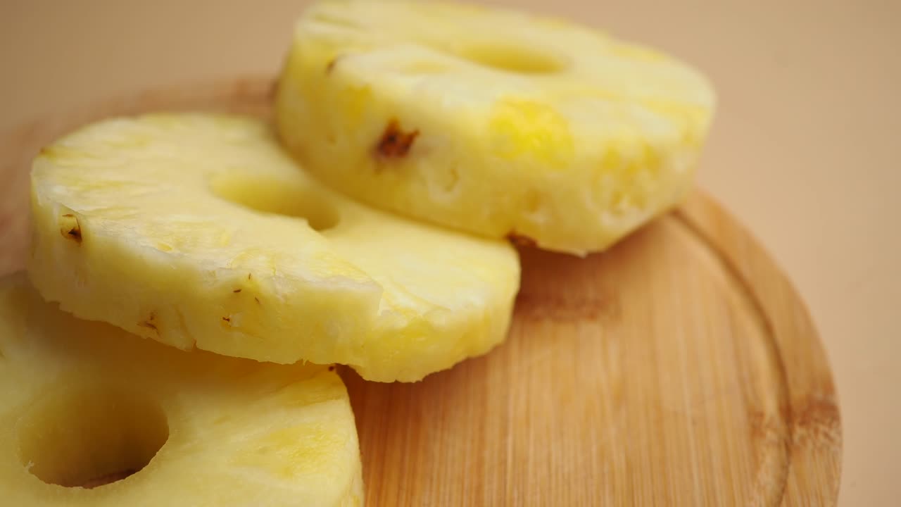 Fette di Ananas Fresco Impilate su un Tagliere di Legno.