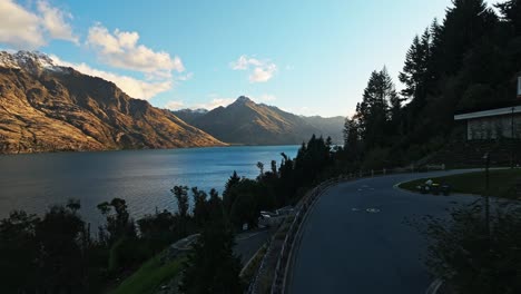 Dolly-Aéreo-Sigue-Una-Carretera-Recta-Con-Vistas-Al-Lago-Wakatipu-Desde-Queenstown