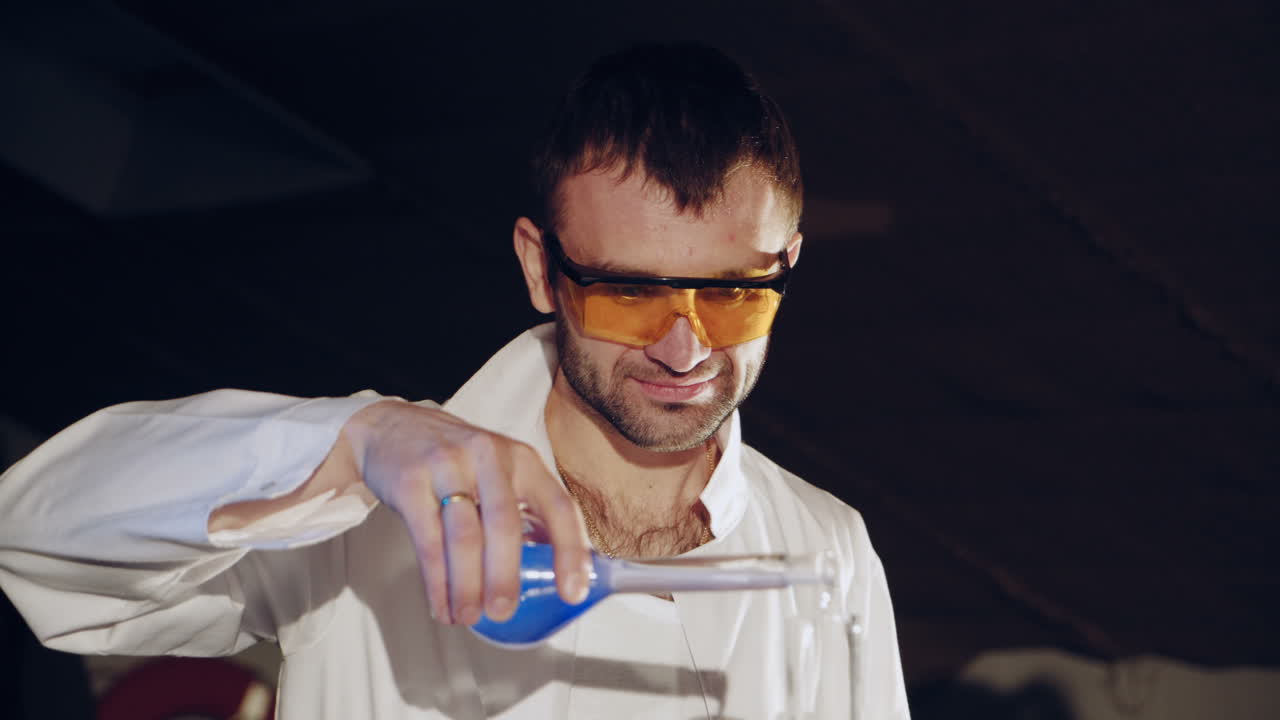 Woman scientist mixing together two liquid substances. Experiments in a chemistry lab. Close-up