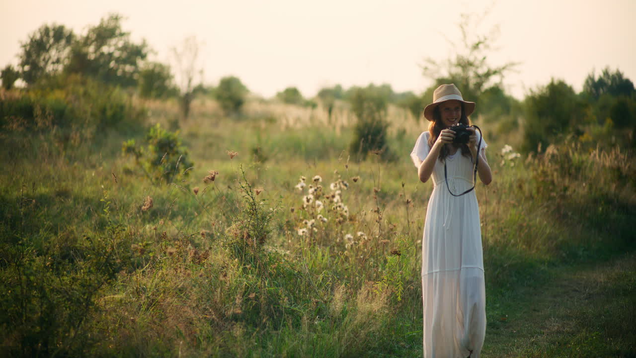 Smiling girl taking photos in the fields