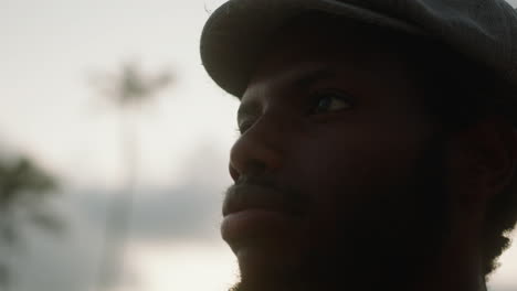 Close-up of a young black man on an exotic beach with palm trees in the background