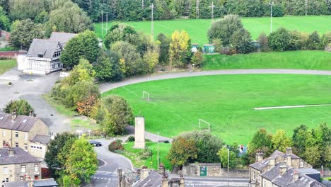 aerial de campos de fútbol y rugby por edificios en huddersfield, reino unido