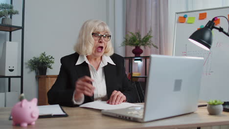 senior business woman analysing paperwork documents shocked by sudden win victory, good news, wow
