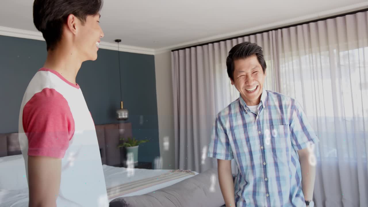 Father and teenage son talking by bed sparking floating tech scribble drifting across frame bonding