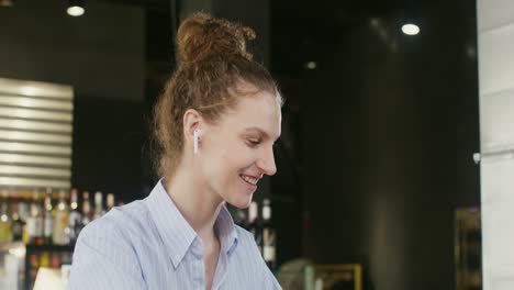 woman with earphones in a cafe