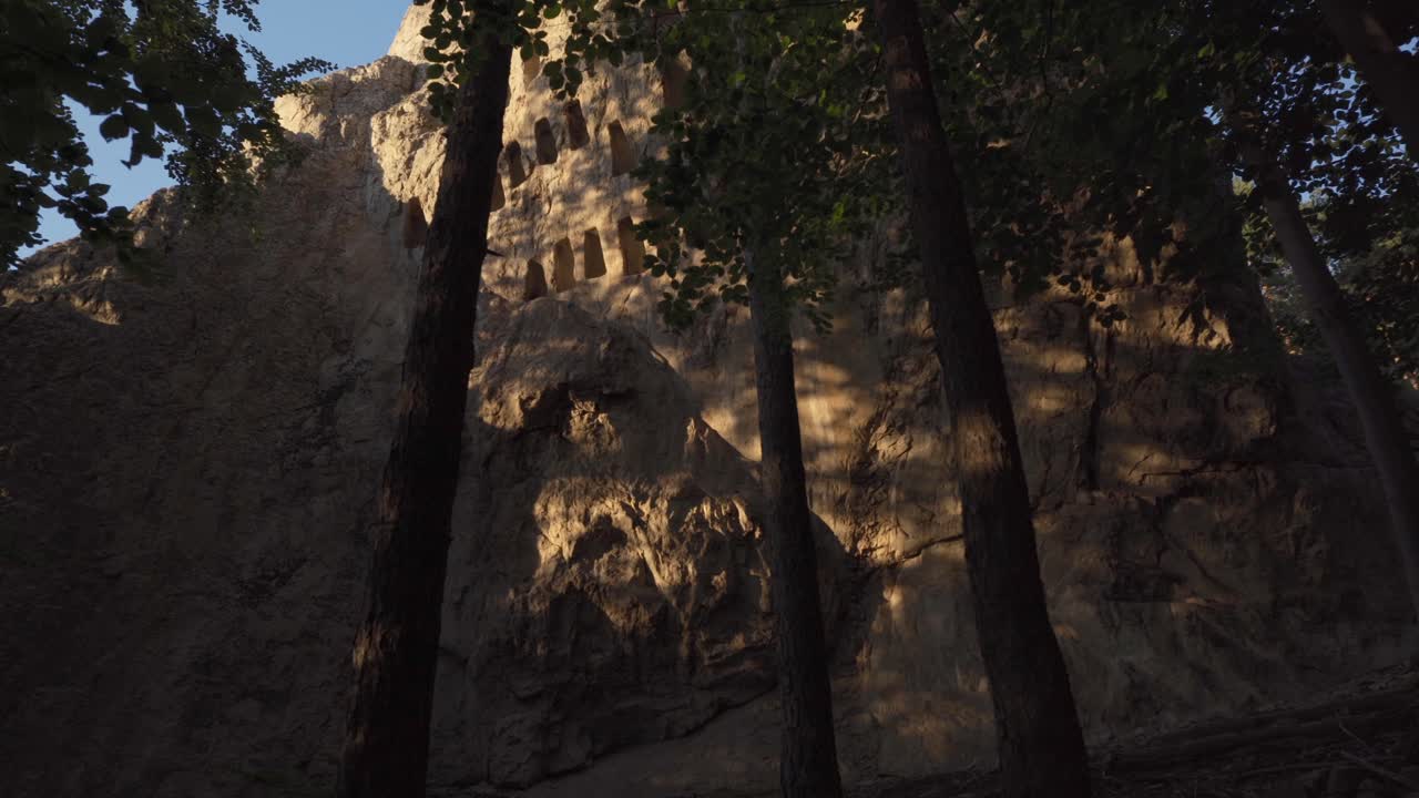 vista desde abajo de los nichos en forma de colmena de un santuario tracio llamado roca del águila o orlovi skali en la montaña rodope en bulgaria