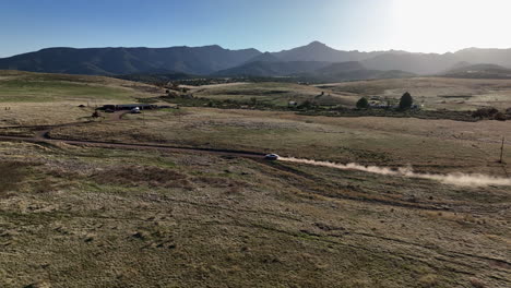 drone shot of car driving on dirt road in willcox, arizona, tracking aerial shot