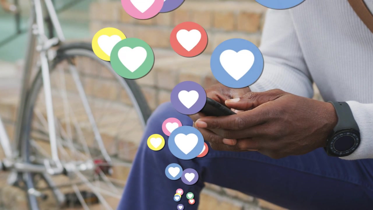 Man tapping smartphone on bench, initiating animated hearts rising past hands for social marketing