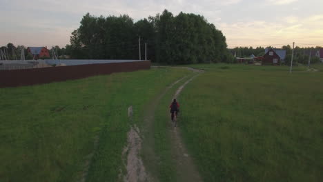 Steadicam-Luftaufnahme-Eines-Jungen,-Der-Im-Sommer-In-Russland-Fahrrad-Fährt