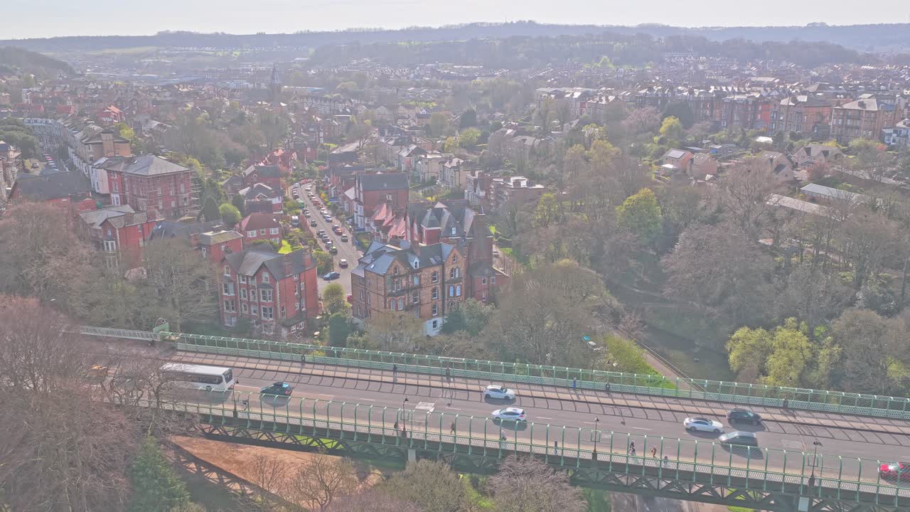 Il Valley Bridge trasporta la A165 sopra i Valley Gardens a Scarborough, North Yorkshire, Inghilterra, Regno Unito, con gli edifici vittoriani di South Cliff e il paesaggio urbano, ripresa aerea con allontanamento del drone.