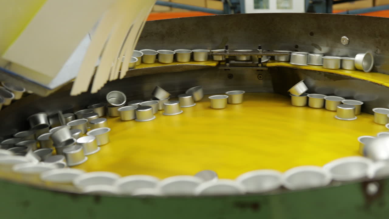 분류를 위해 큰 드럼에서 회전하는 진동 상자 공급 장치의 금속 둥근