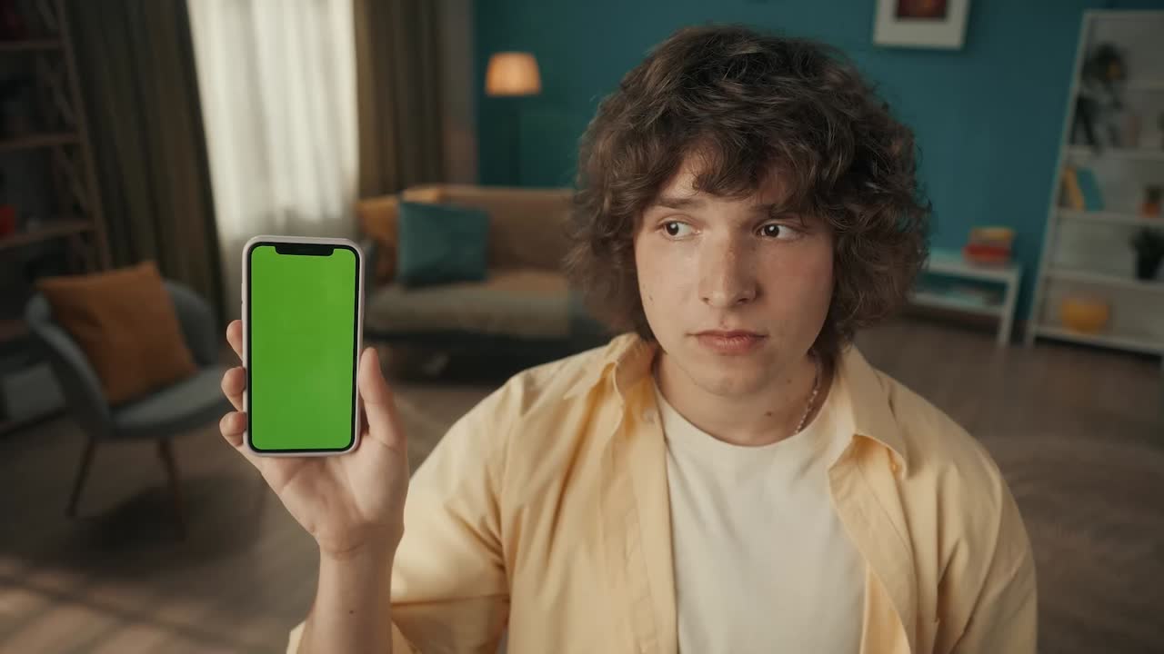Young Person Holding Smartphone with Green Screen