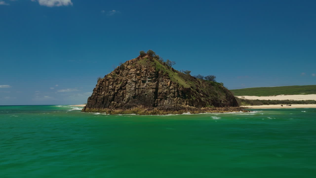 Panoramica aerea panoramica con drone intorno alla costa rocciosa di Indian Head, sponda blu di KGari Fraser Island, Australia 4K