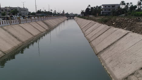 aerial shot track in and rising up for the pyramids of egypt in giza in the background of a branch of the river nile in the foreground maryotya branch