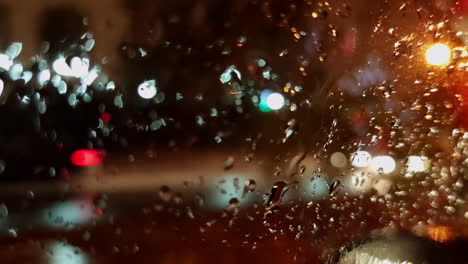 Vista-Del-Tráfico-Que-Pasa-A-Través-De-La-Ventana-Del-Camión-Mojado-Con-Gotas-De-Lluvia-En-La-Noche