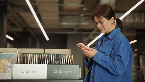 Woman Browsing Tile Samples in a Retail Store