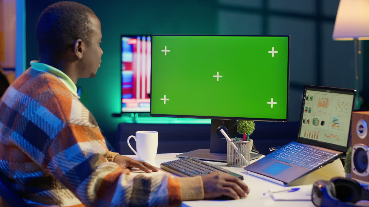 Man Working on Computer with Green Screen