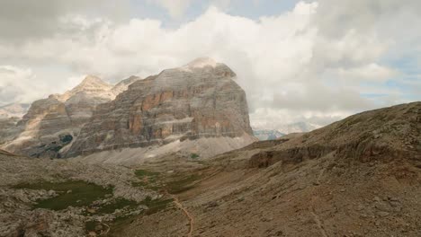 El-Dron-FPV-Acelera-Y-Conquista-La-Colosal-Montaña-Col-De-Bos-En-Los-Dolomitas-Italianos,-Bajo-Un-Cielo-De-Verano-Parcialmente-Nublado.