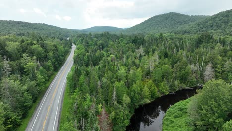 small river snaking through forests of the mountain range