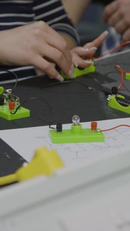 disparo vertical de las manos de los estudiantes mientras trabajan en un proyecto de ingeniería de grupo