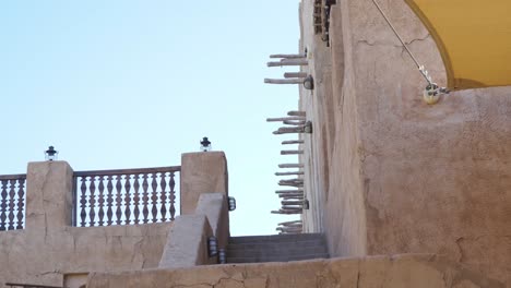 Fachada-Exterior-Con-Escaleras-Contra-El-Cielo-Despejado-En-El-Patrimonio-Histórico-Del-Distrito-De-Al-Fahidi-En-Dubai,-Emiratos-árabes-Unidos