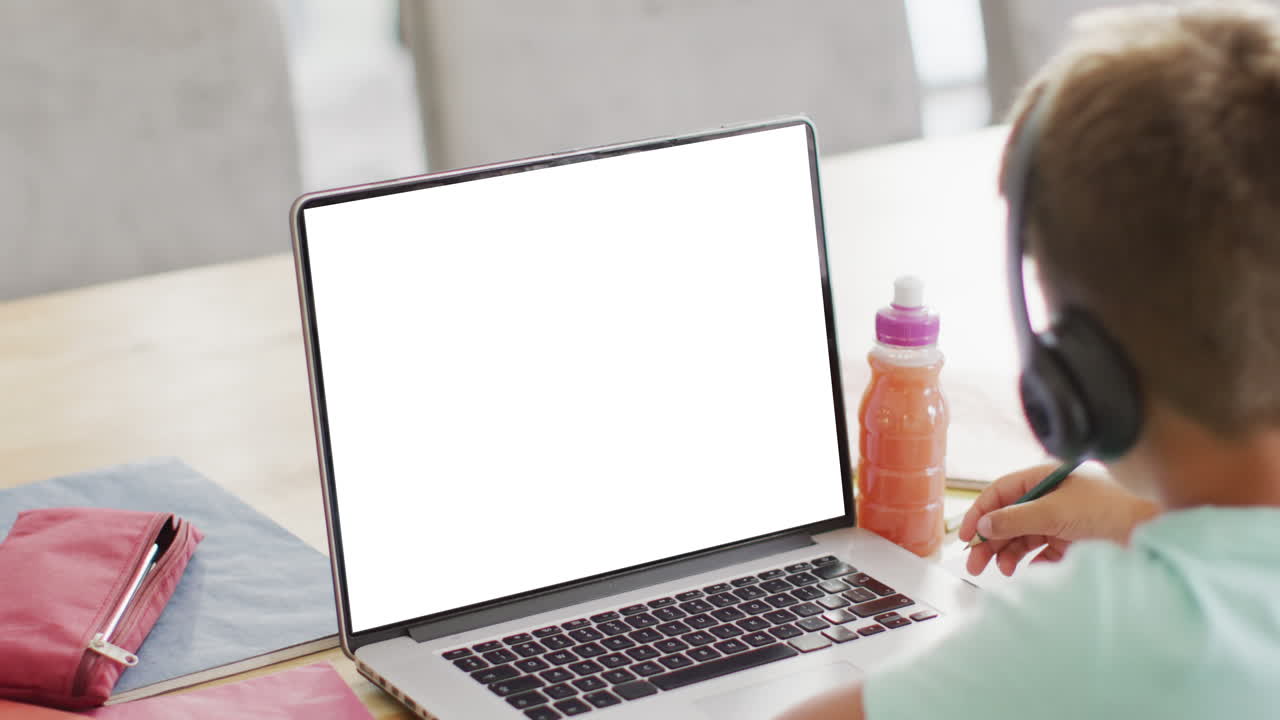 Composition of caucasian schoolboy on laptop online learning with blank screen