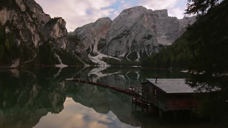 Statische-Aufnahme-Des-Pragser-Wildsees,-Ikonisches-Bootshaus-Und-Boote-In-Einer-Reihe,-Bergspiegelung-Im-Hochgebirgssee-Der-Italienischen-Dolomiten,-Von-Dem-Viele-Menschen-Träumen,-Dorthin-Zu-Reisen-Und-Ihn-Zu-Erleben