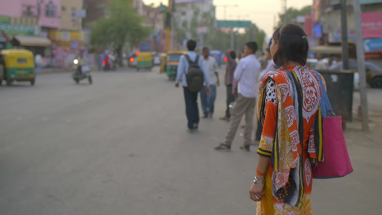 전통적으로 옷을 입은 인도 여인이 길가에 서 있었다