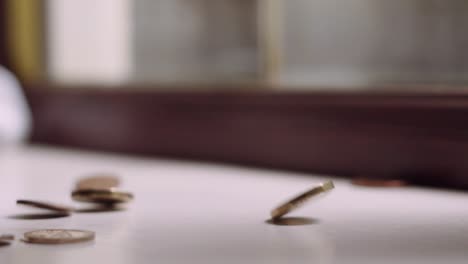 british coins falling in slow motion with window background