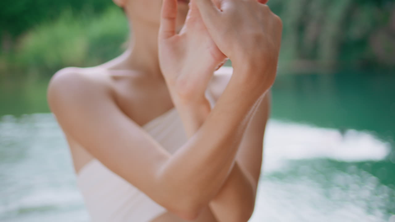 열대 연못에서 손을 따뜻하게 하는 운동선수. 팔을 펴고 있는 건강한 여성