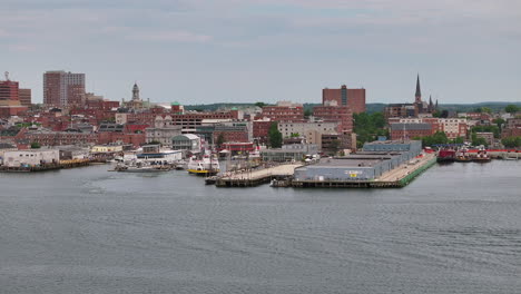 Portland-Maine-ferry-terminal-along-harbor,-downtown-district-skyline-backdrop