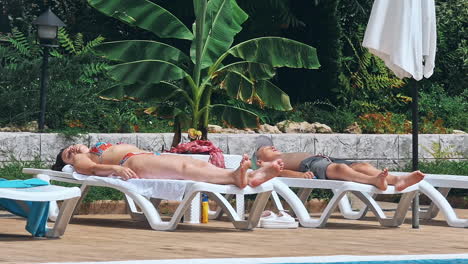 people sitting by the poolside of a resort swimming pool