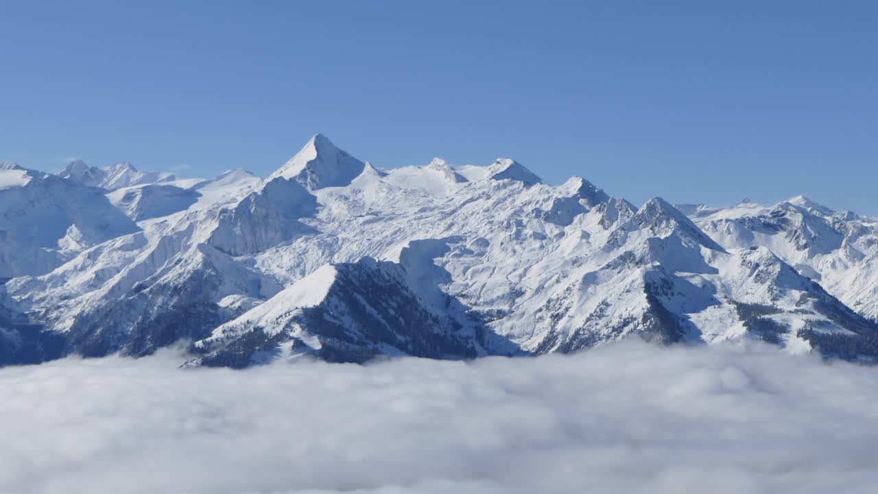 눈 덮인 산이 안개 위로 솟아 있습니다. 시간 경과
