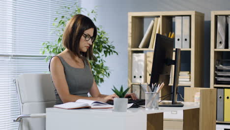 pregnant businesswoman working in the office at desk and then rests while caressing her belly