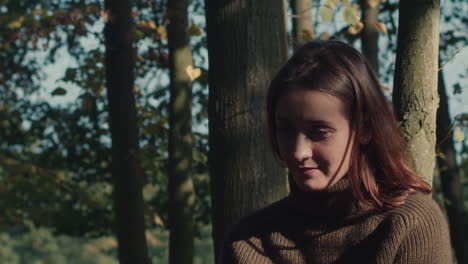 young woman in a forest takes off her headphones and listens to the sound of nature