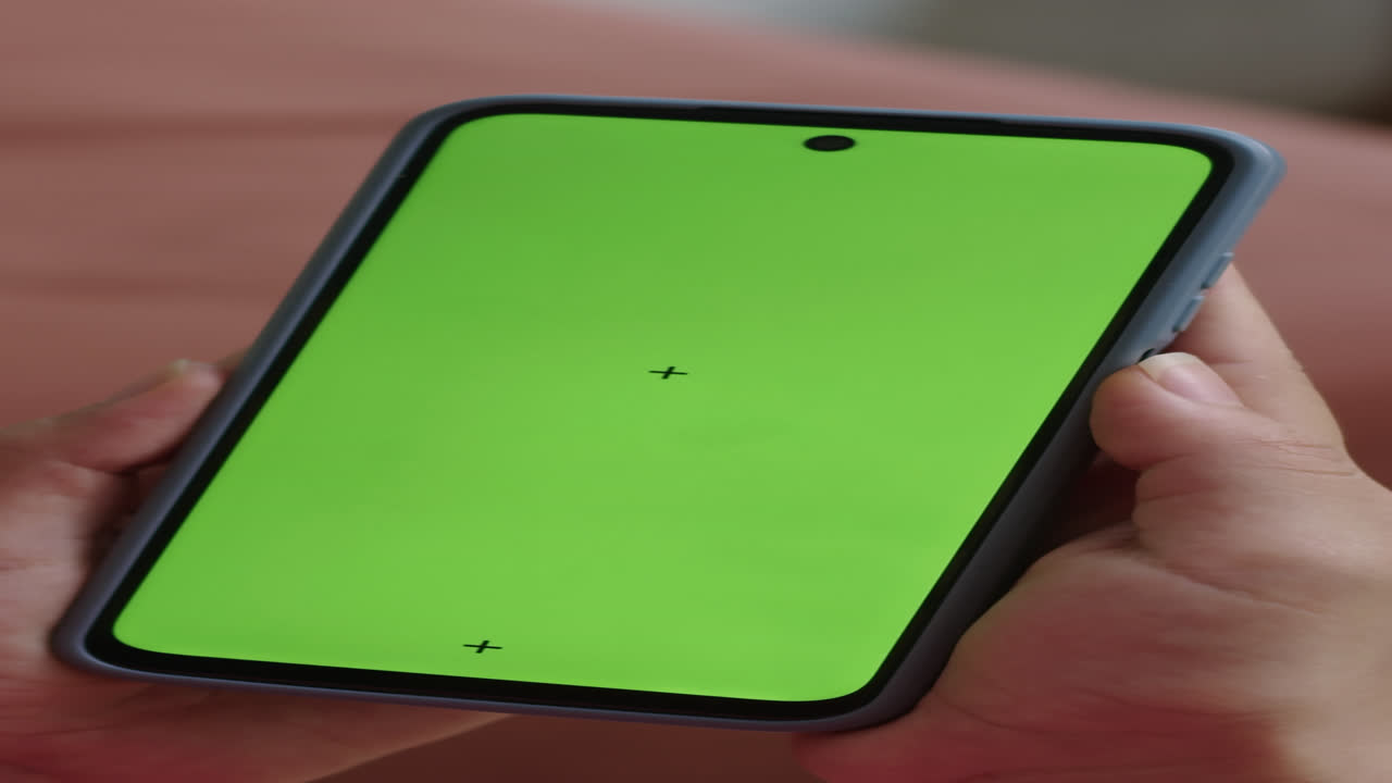 Verticale di persona che scorre su un telefono cellulare con schermo verde
