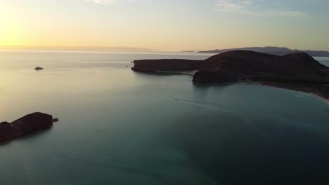 Boat-sailing-in-Bahia-Balandra,-Baja-California-Sur-during-sunset