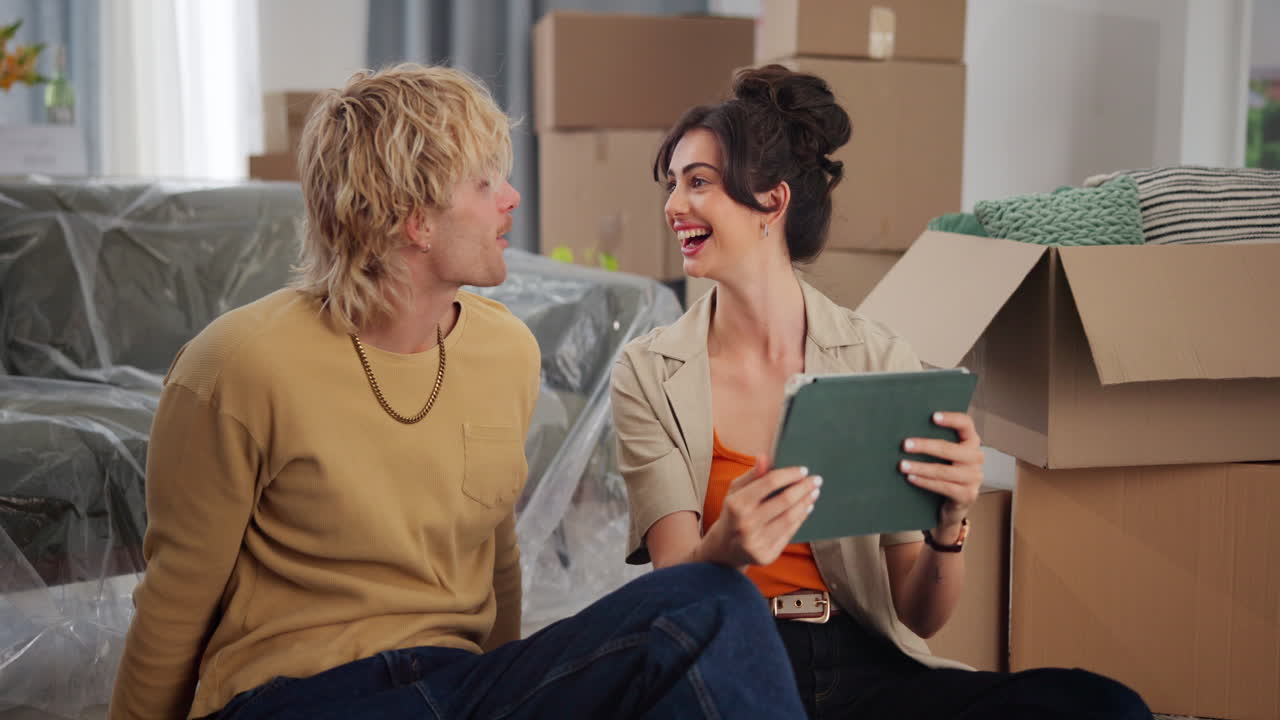 Happy Young Couple Planning Their New Home with a Tablet