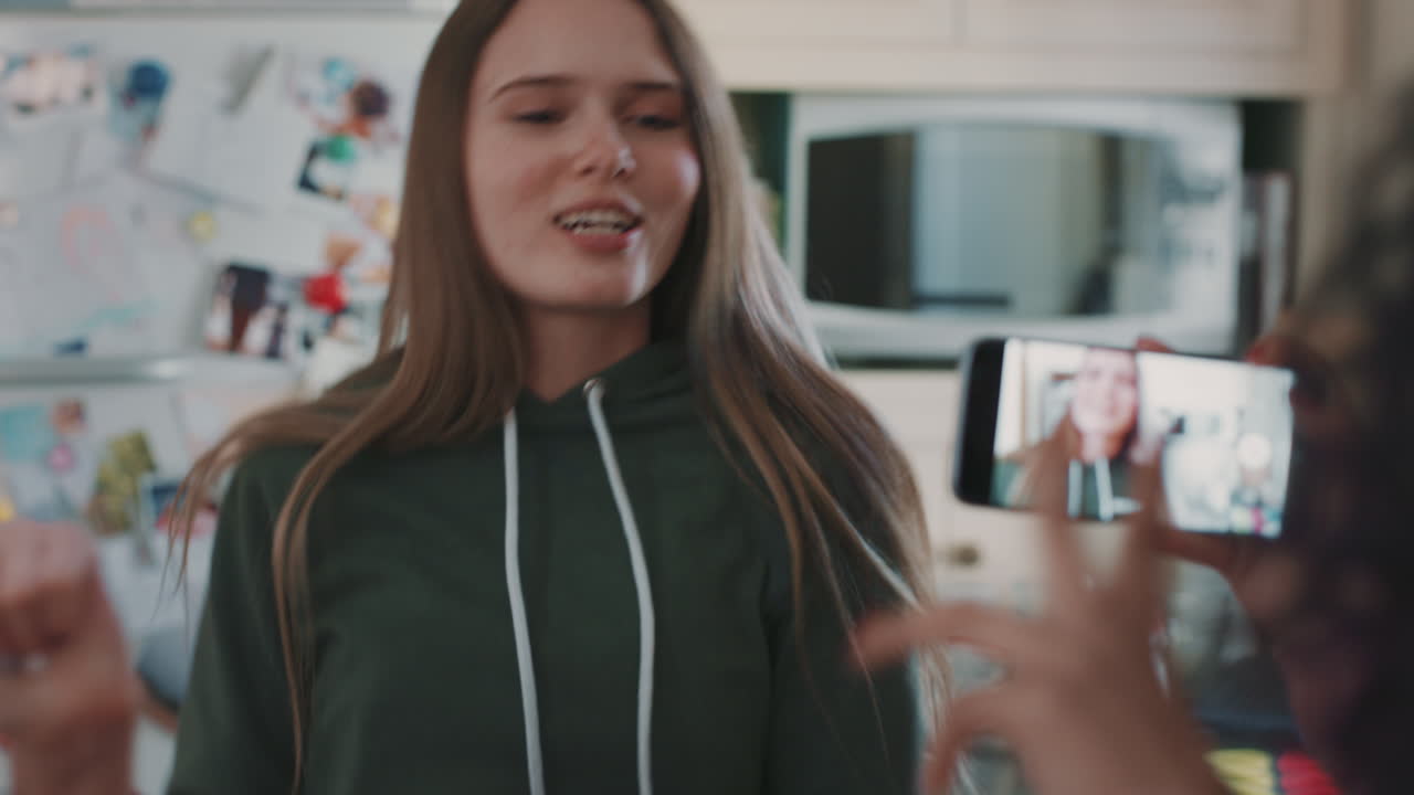 adolescentes felices bailando en la cocina comiendo pizza divirtiéndose celebrando juntos amigos usando teléfonos inteligentes compartiendo celebraciones en las redes sociales disfrutando del fin de semana