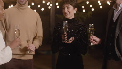 group of four happy multiethnic friends toasting and drinking champagne at new year's eve party 2