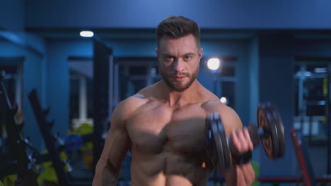 fitness muscular man training his biceps in the gym. handsome bodybuilder working hard at gym.