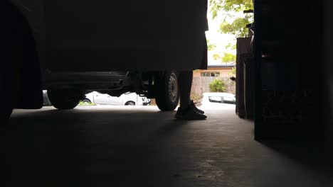 Silhouette-of-man-exiting-a-ute-from-the-drivers-side-in-jeans-and-walking-into-the-house-in-dark-garage-lit-by-the-outside-light