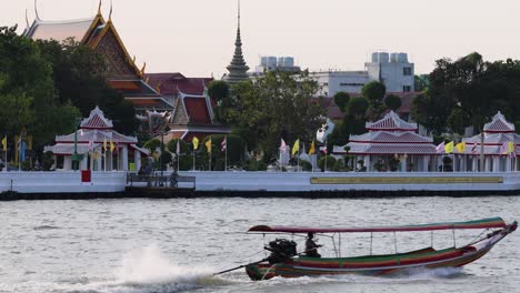 speedboat in motion on river by cultural landmarks