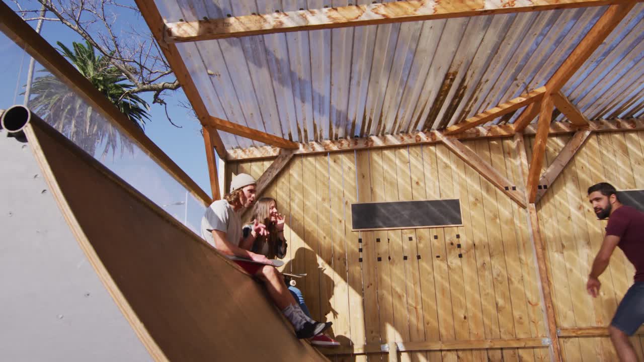 видео счастливых разнообразных скейтбордистов-женщин и мужчин, тренирующихся в скейт-парке