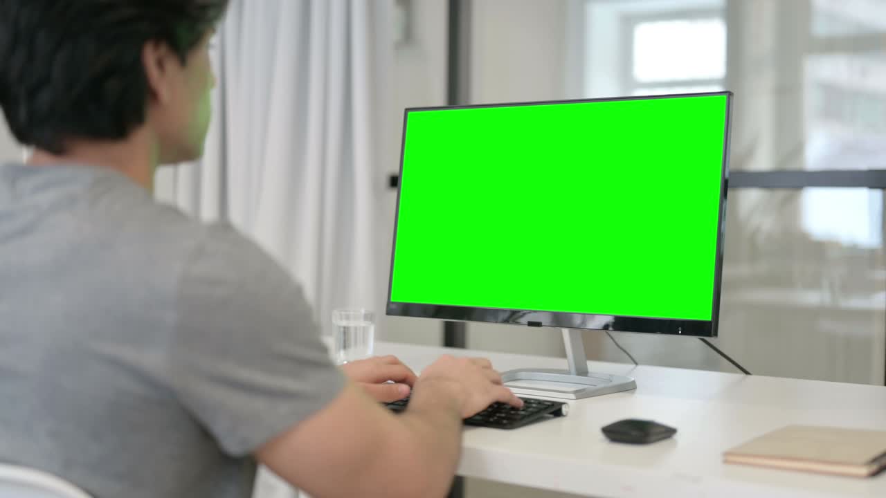 녹색 크로마 키 스크린을 가진 데스크을 사용하는 사업가