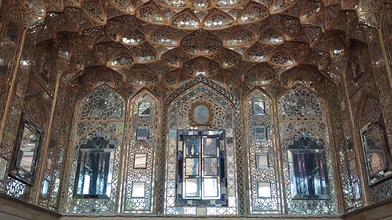 Intricate lavorazioni a specchio e soffitto ornato in un palazzo persiano storico.