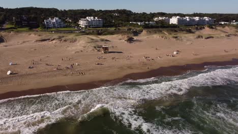 Many-People-relaxing-on-sandy-beach-during-beautiful-sunny-day-in-Punta-del-Este-City,-Uruguay